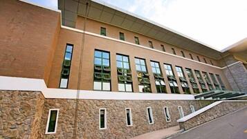 A modern building with a stone facade, multiple windows, and a flat roof.