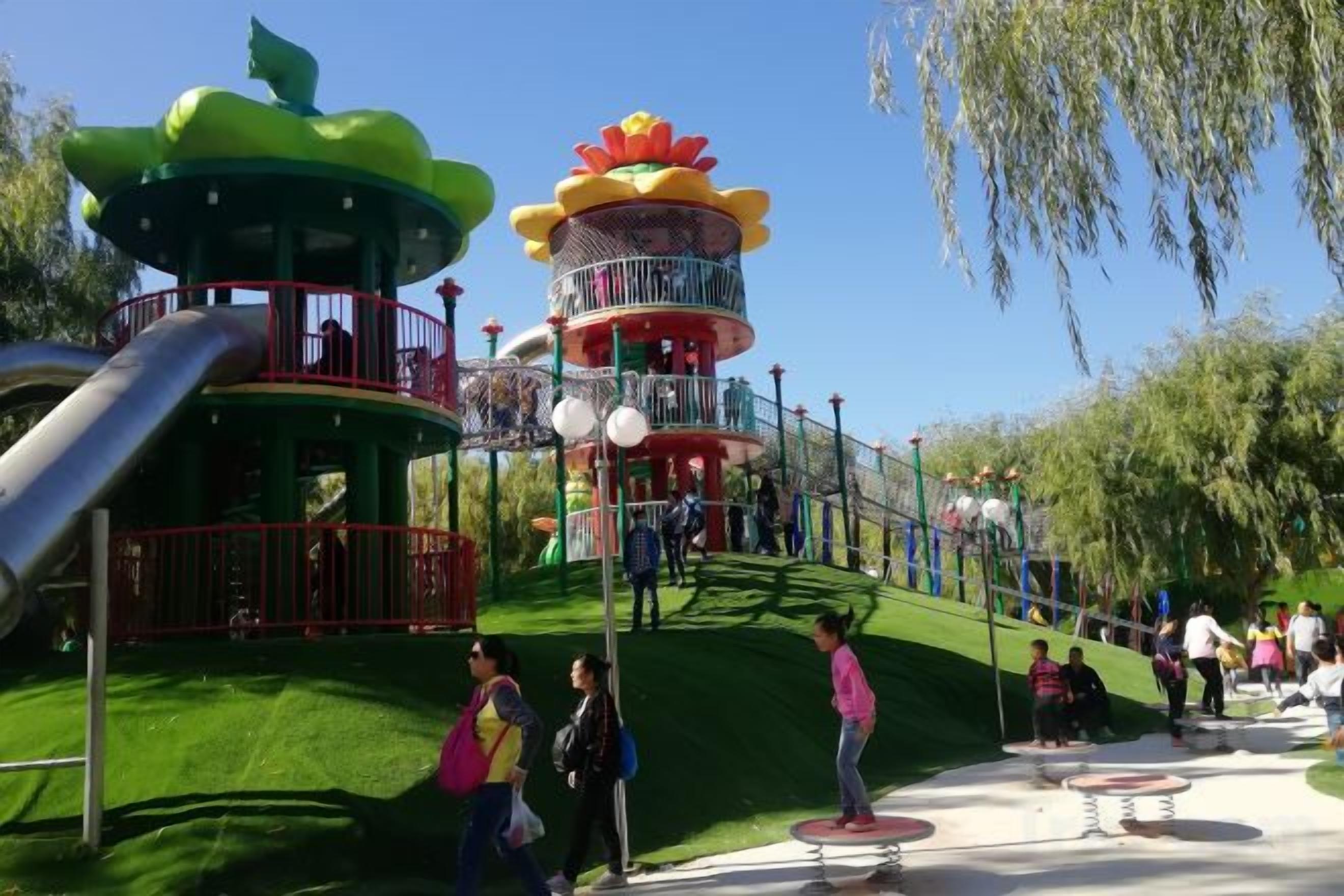 A playground with a slide, a climbing structure, and a circular tower.