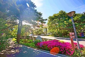 A street with a lamppost, a road sign, and a flower bed. - Beidaihe Dongjinglu Hotel (Qinhuangdao)