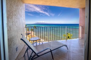 Ein Balkon mit Meerblick, einem kleinen Tisch und einem Stuhl.