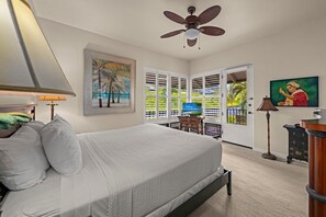 A bedroom with a bed, a ceiling fan, a painting, a television, and a door leading to a balcony. - Kapalua Bay Villa 22B4 Gold Oceanfront 1 Bedroom (Lahaina)