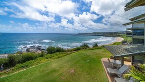 A coastal property with a view of the ocean, a grassy lawn, and a building with a balcony overlooking the beach. - Kapalua Bay Villa 22B4 Gold Oceanfront 1 Bedroom (Lahaina)