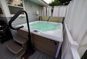 Ein Whirlpool mit Bedienfeld, einer Stufe und einem Schlauch.