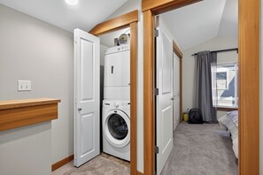 A laundry room with a washing machine, a dryer, and a small fan. - Stylish Townhome Near Alki Beach & Downtown (Seattle)
