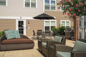 A patio with wicker furniture, a grill, and a covered dining area. - 1BR King Sofa | Marriott Salisbury | Extended Stay, Hot Breakfast, Eastern Shore (Salisbury)