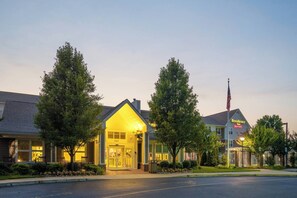 A hotel with a well-lit entrance, large windows, and a flagpole with an American flag. - 1BR King Sofa | Marriott Salisbury | Extended Stay, Hot Breakfast, Eastern Shore (Salisbury)