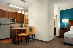A hotel room with a kitchenette, a bed, a desk with chairs, and a bathroom. - 1BR King Sofa | Marriott Salisbury | Extended Stay, Hot Breakfast, Eastern Shore (Salisbury)