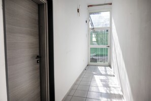 A narrow hallway with a door on the left and a window on the right. - Alter 26 Urban Apartment with free parking, Koper, Slovenia (Koper)