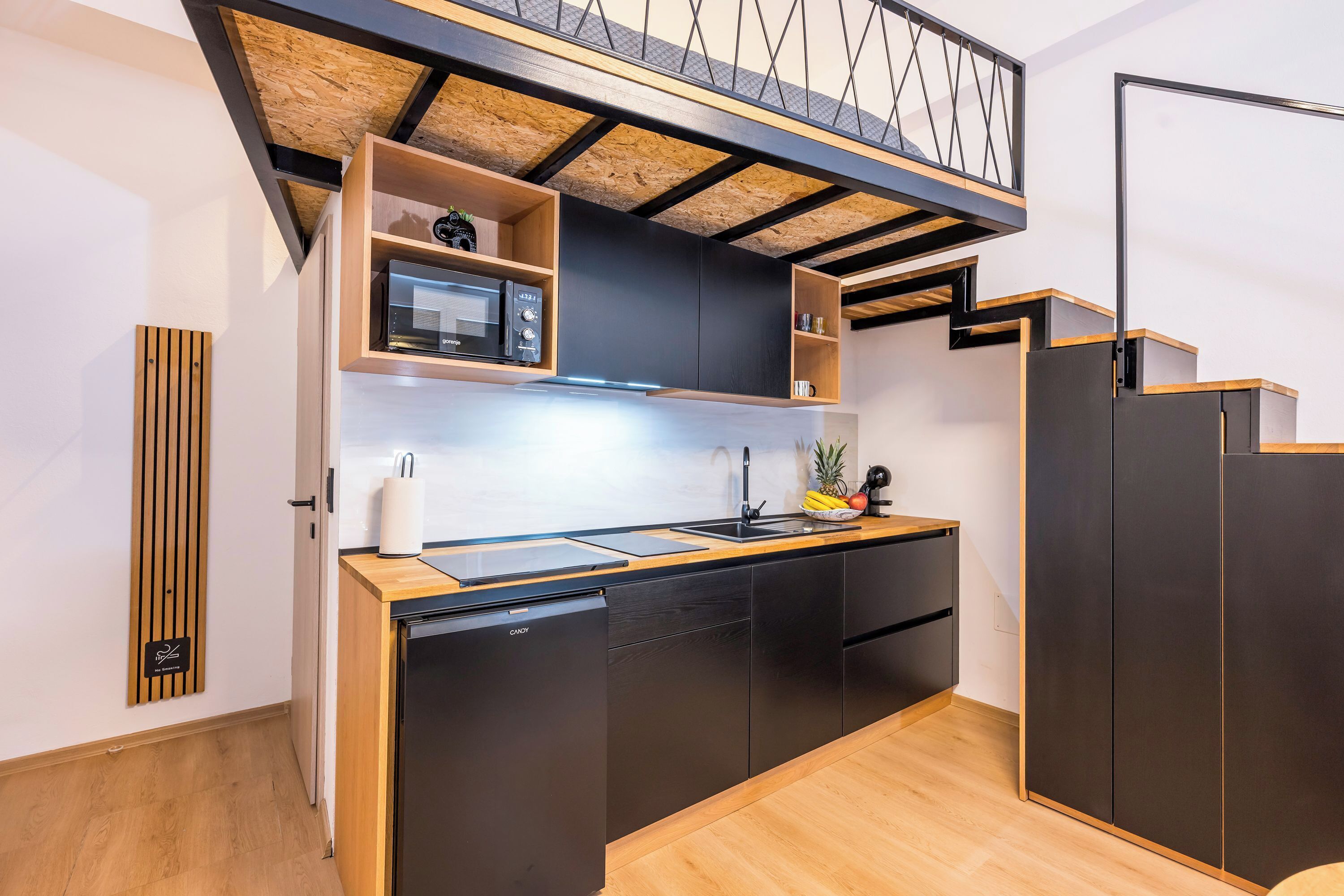 A compact kitchen with a built-in microwave, a sink, and a dishwasher.