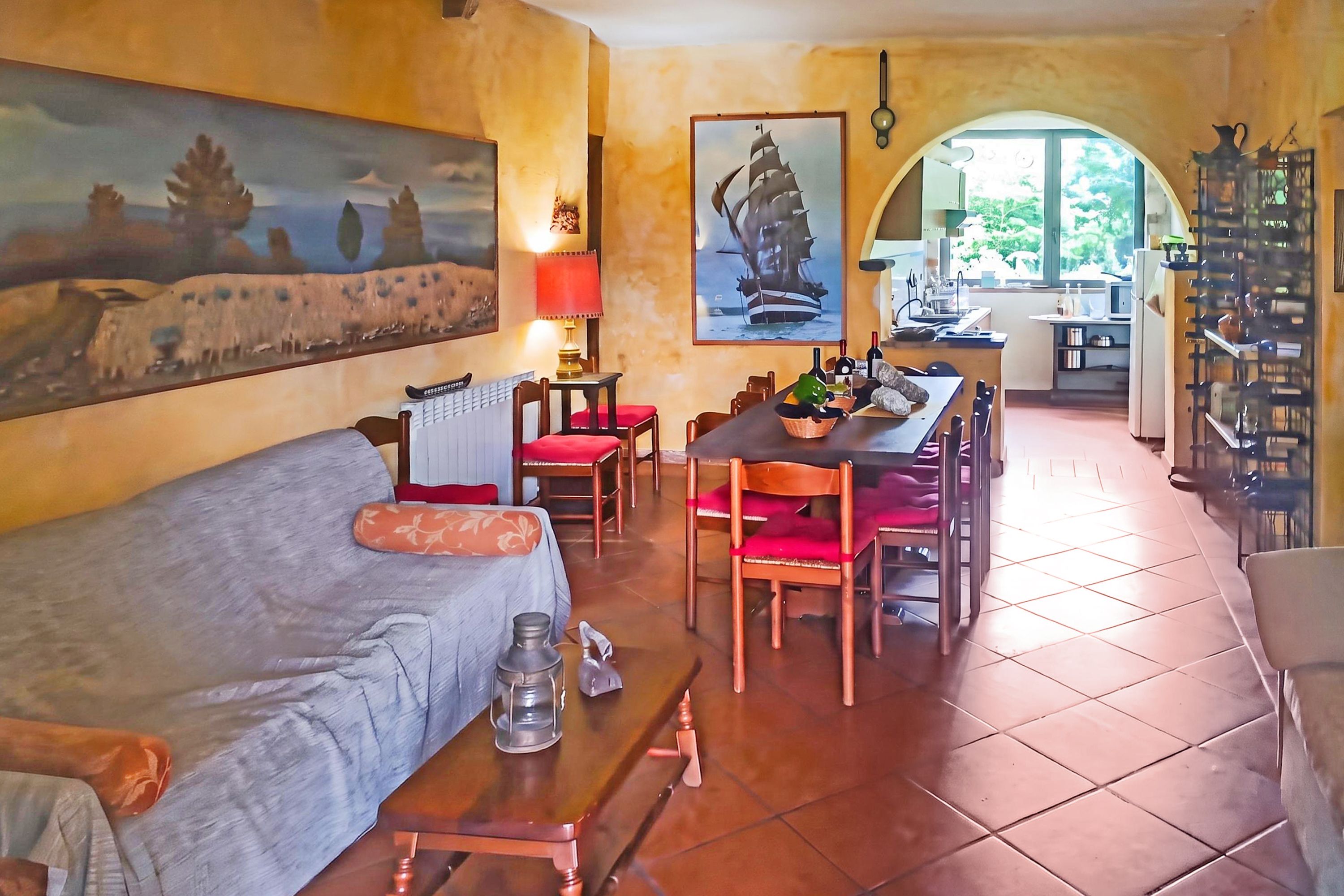 Un salon chaleureux avec un canapé, une table à manger, des chaises et un tableau.