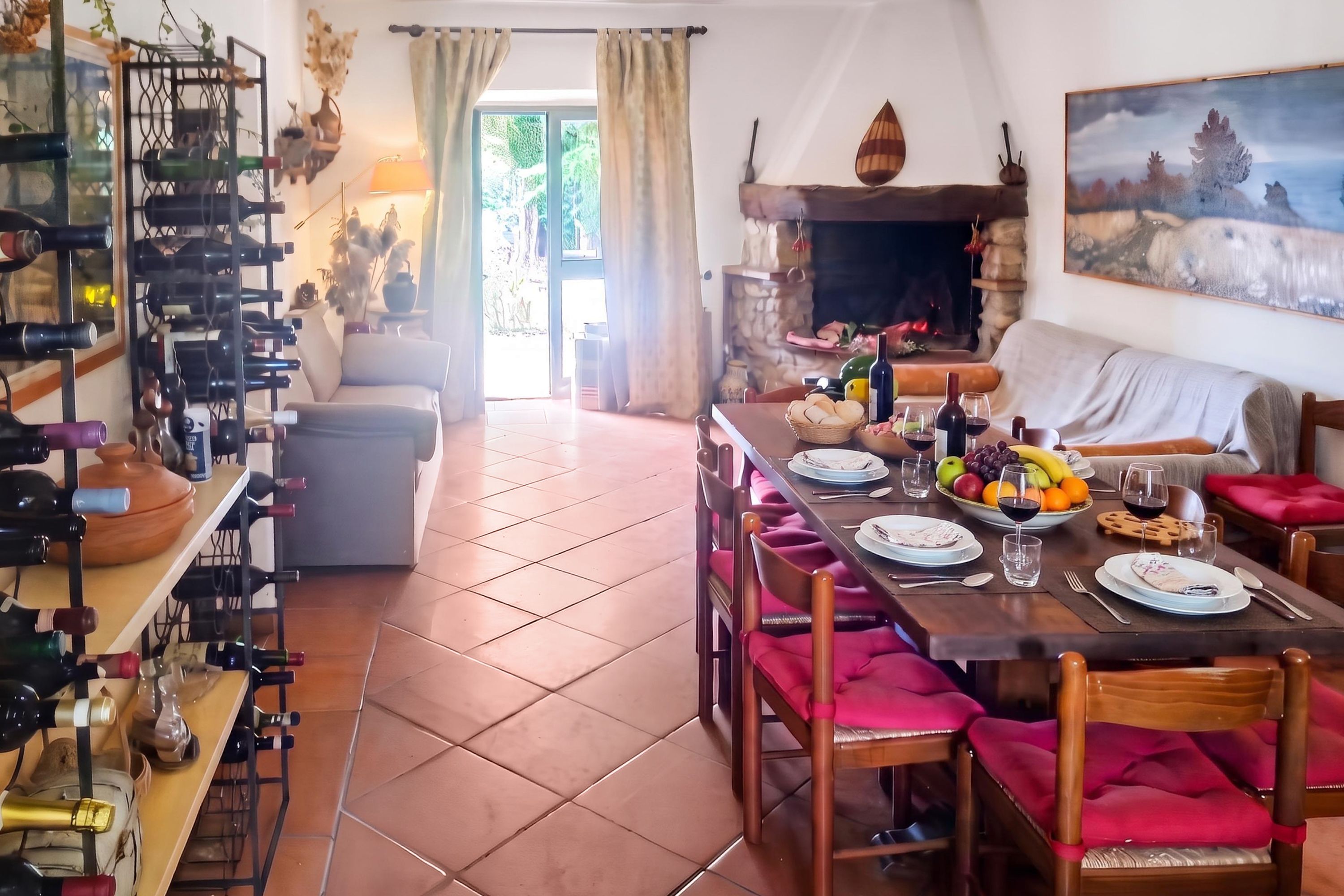 Un coin repas avec une table dressée pour quatre personnes, un meuble à vin et une cheminée.