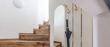 A staircase with wooden steps and a white wall.