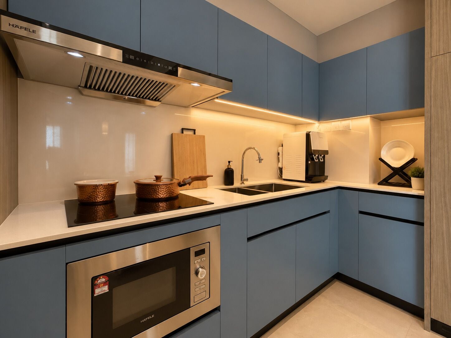 A modern kitchen with stainless steel appliances, a sink, and a coffee machine.