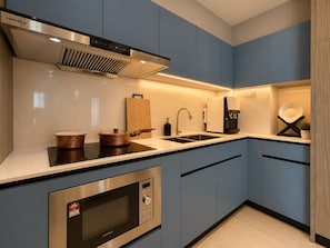 Una cocina moderna con electrodomésticos de acero inoxidable, un lavamanos y una cafetera.