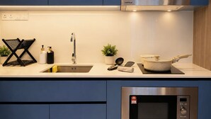 Una cocina moderna con un microondas de acero inoxidable, un fregadero y una estufa.