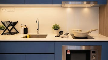 A modern kitchen with a stainless steel microwave, a sink, and a stove.