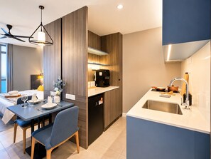 Una cocina moderna con lavavajillas incorporado, un comedor con mesa y sillas, y un ventilador de techo.