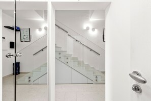 A modern interior with a glass door, a staircase, and a wall-mounted control panel. - Pure Bliss Villa With Jacuzzi, Tisno, Croatia (Tisno)