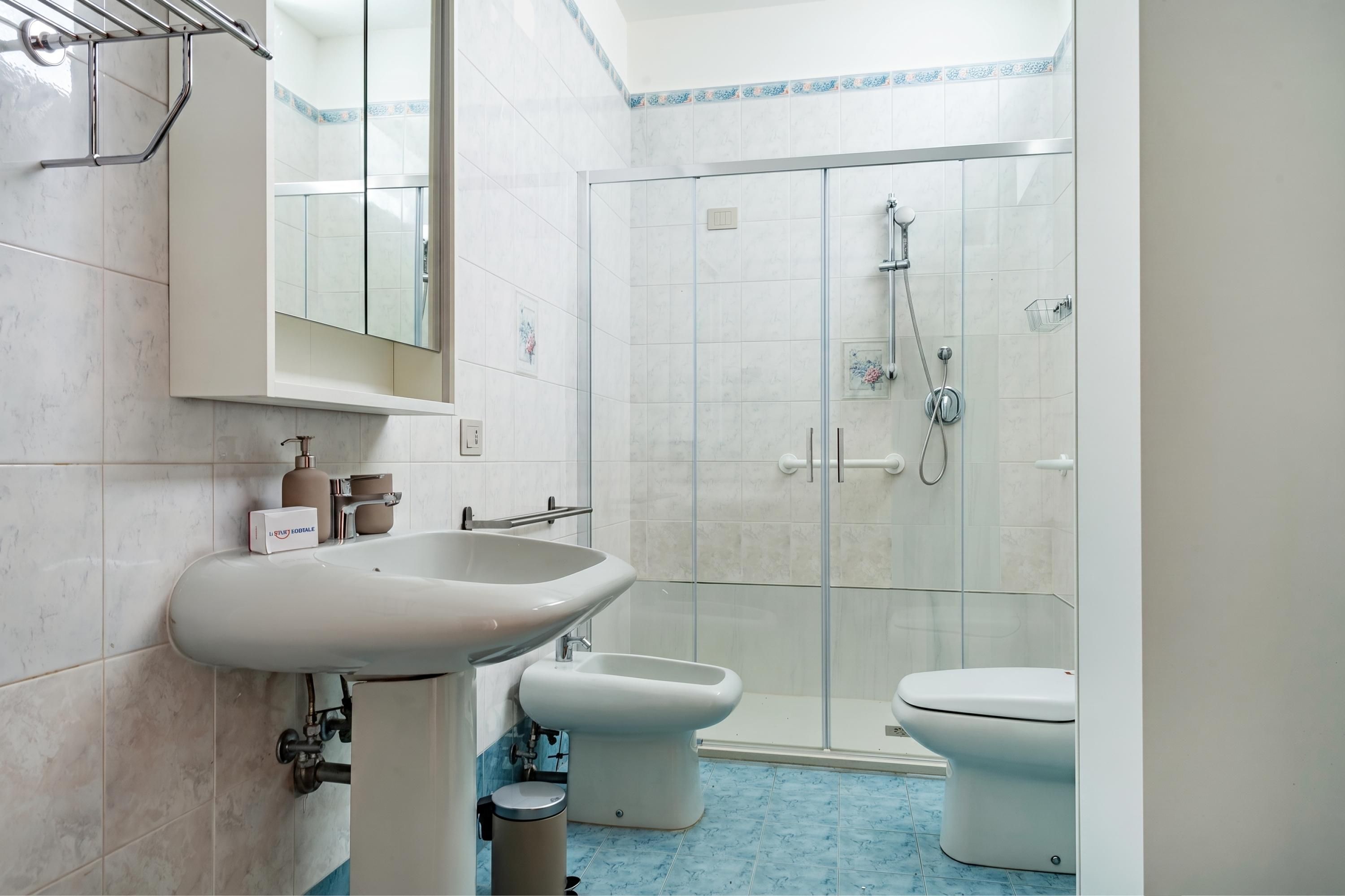 A bathroom with a sink, toilet, and shower.