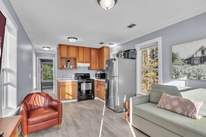 A modern kitchen with wooden cabinets, a stainless steel refrigerator, and a built-in oven.