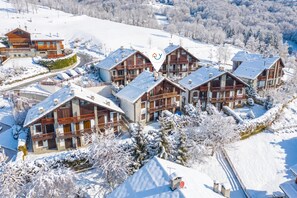 A snow-covered resort with multiple chalet-style buildings, a ski lift, and a mountainous backdrop. - Alpine Loft Sommeiller, Bardonecchia, Italy (Bardonecchia)
