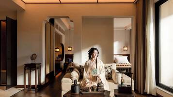 A traditional Japanese-style room with tatami flooring, a low table with tea set, and a large mirror.