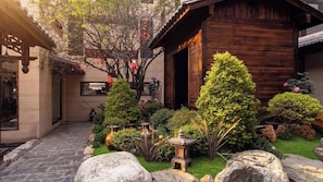 A traditional Japanese-style garden with a wooden building, stone lanterns, and well-maintained shrubs. - Yunye Fengwan Song's Aesthetic Hotel (Deqin)