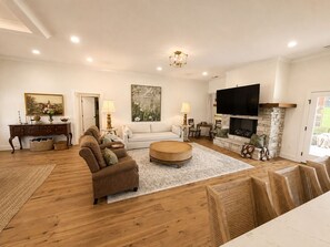 A living room with a fireplace, a sofa, a coffee table, and a television.
