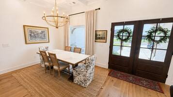 A dining area with a table, chairs, and a chandelier.
