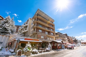A multi-story building with balconies, a restaurant, and a parking area. - Appartamento Venus 11, Sestriere, Italy (Sestriere)