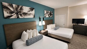 A hotel room with two beds, a TV, a desk, and artwork on the walls. - Fully Renovated Direct Oceanfront Corner Unit Perfect for Family Gateway (Myrtle Beach)