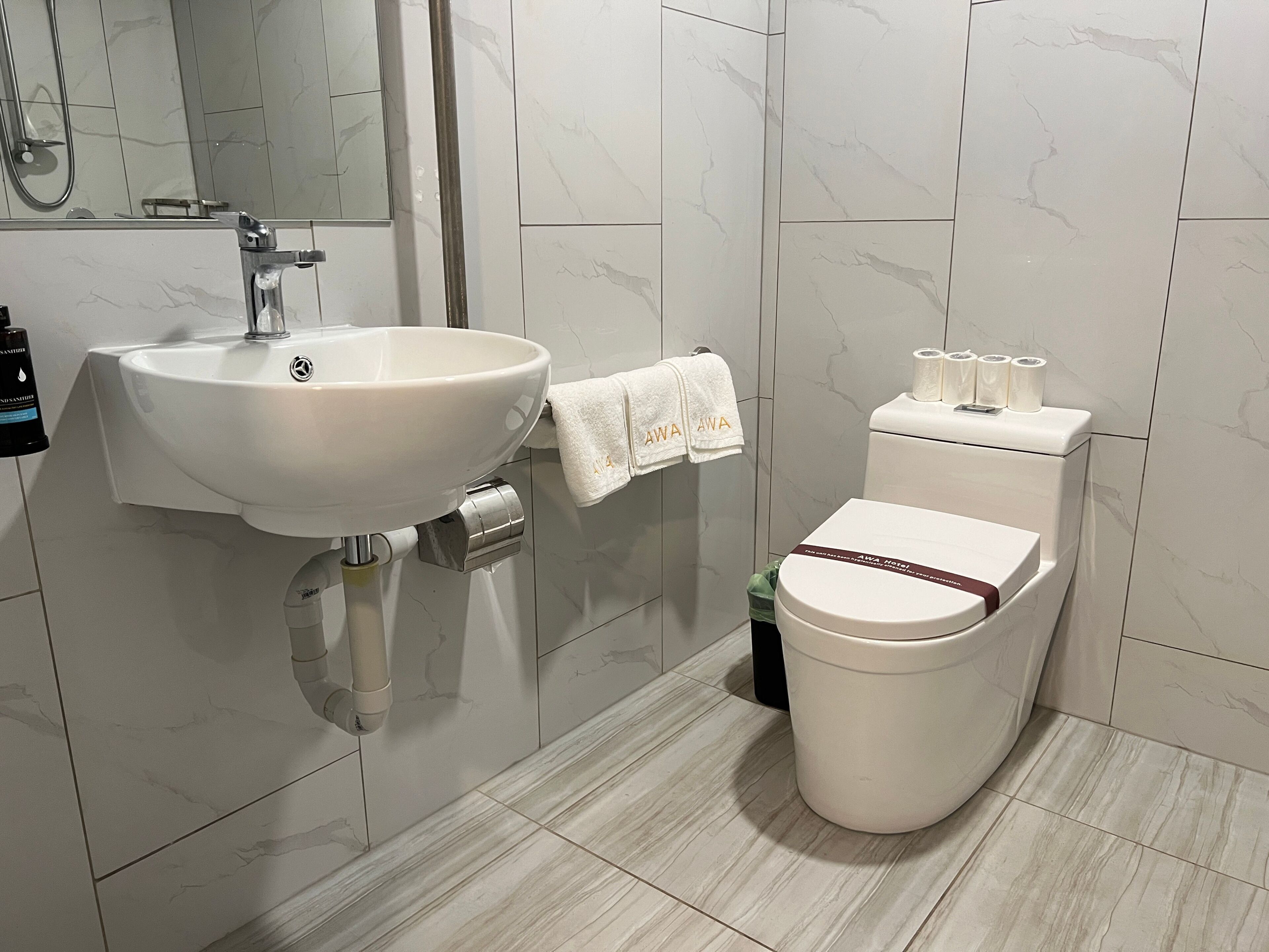 A bathroom with a white sink, a toilet, and a mirror.