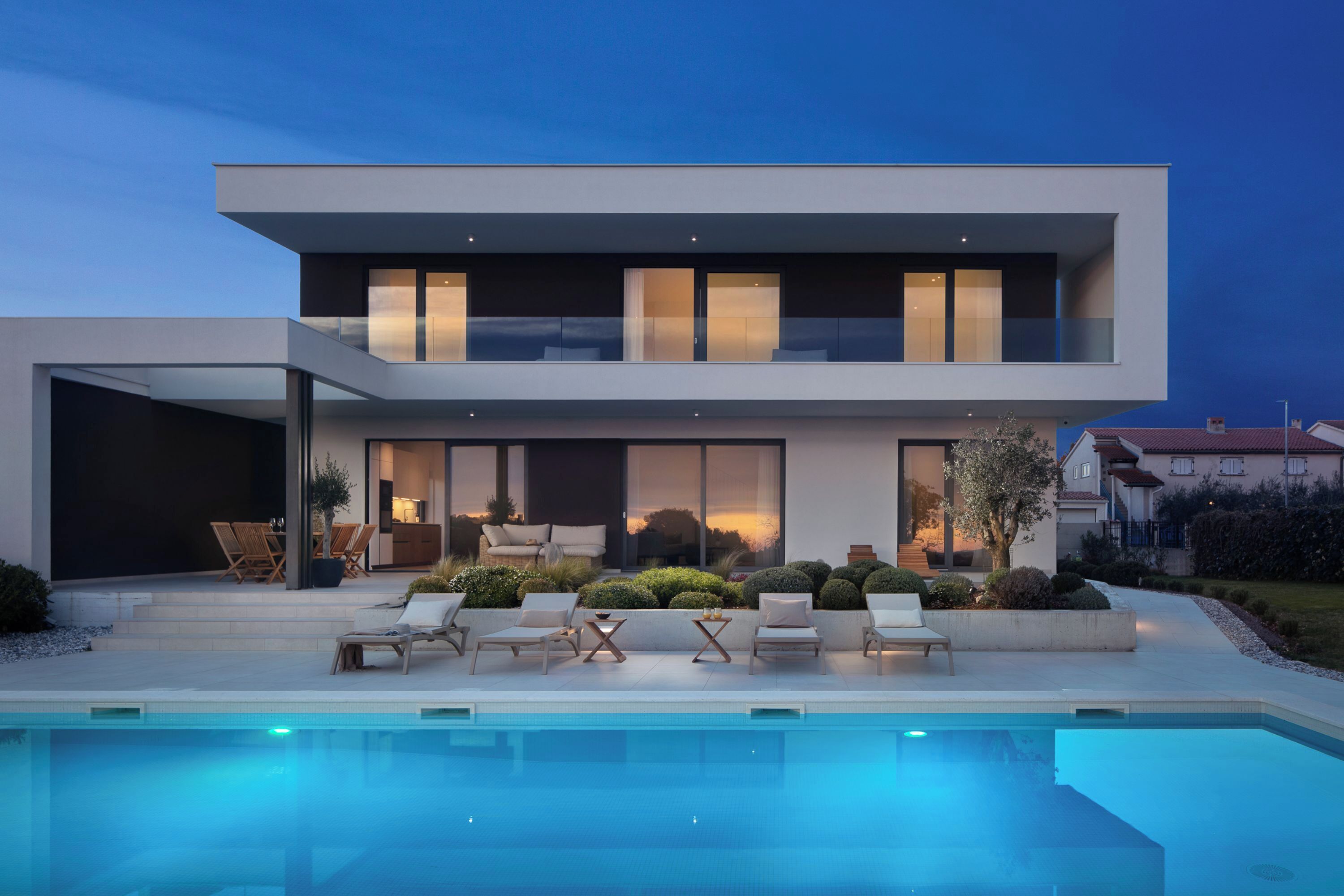 Een modern herenhuis met zwembad, terras en een verzorgde tuin.