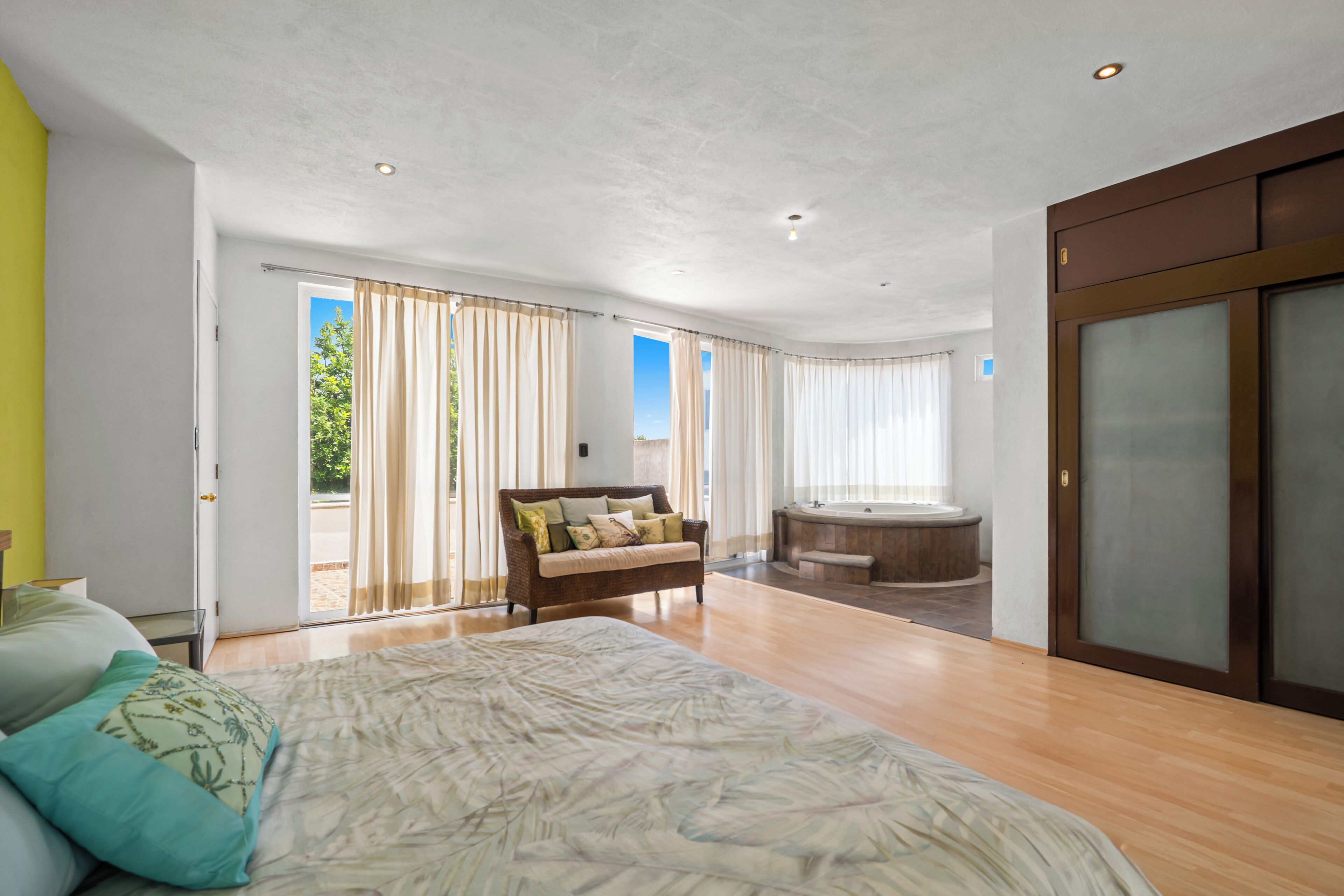 Une chambre spacieuse avec un grand lit, un canapé et une baignoire.