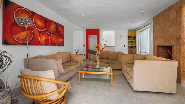 A modern living room with two sofas, a coffee table, and a large abstract painting.