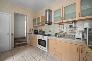 A kitchen with a stove, oven, and various utensils.