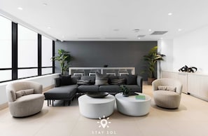 A modern living room with a sectional sofa, two armchairs, and a coffee table. - Miami Luxury Studio Rooftop Resort Style (Miami)