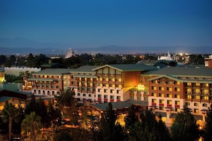 A hotel with multiple buildings, a prominent tower, and a view of distant mountains. - Anaheim | Romantic Disney Retreat | Pool + Spa (Anaheim)