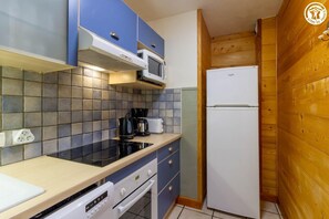 A compact kitchen with a microwave, stove, and refrigerator. - Chalet de l'Arbé 2 - No. 6 (LA PLAGNE TARENTAISE)