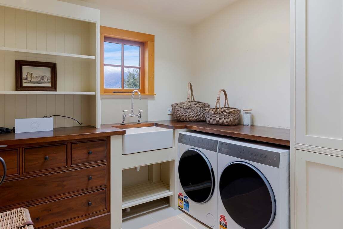 Una sala de lavandería con lavadora, lavabo y ventana.
