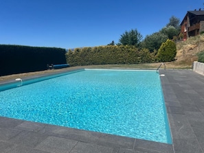 A rectangular swimming pool with clear blue water, surrounded by a paved deck and a hedge. - Apartment 5 People with pool in Saillagouse (Saillagouse)
