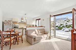 Un espai modern d'estar amb zona de menjador, sofà i cuina.