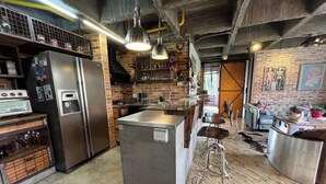 A kitchen with a central island, stainless steel appliances, and a rustic brick wall. - Industrial DesignTerrace El Poblado fast WIFI (Medellín)