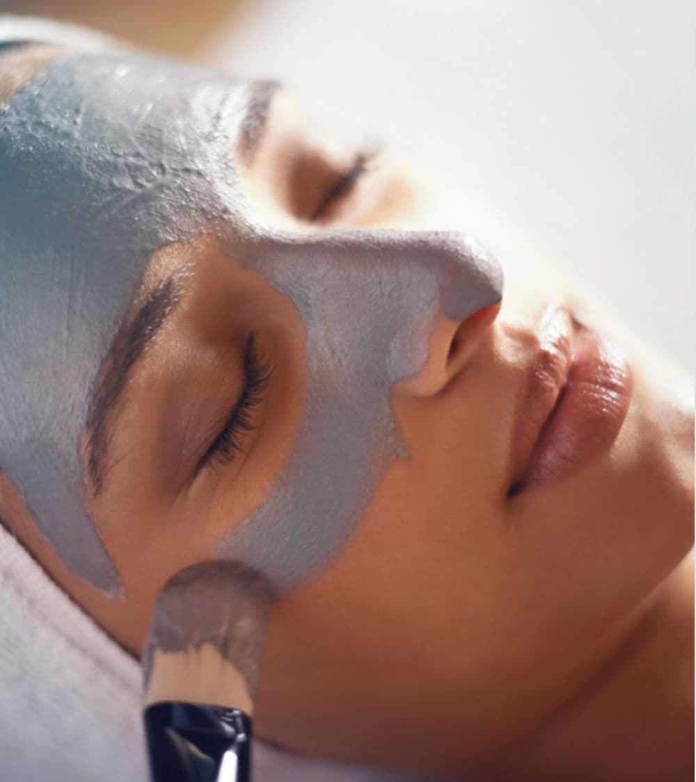 A person lying down with a facial mask applied.