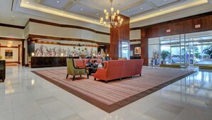 A spacious lobby with a reception desk, a red sofa, and a chandelier. - Penthouse Suite MGM Signature (Las Vegas)