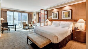 A hotel room with a large bed, a desk, a chair, and a balcony with a city view. - Penthouse Suite MGM Signature (Las Vegas)