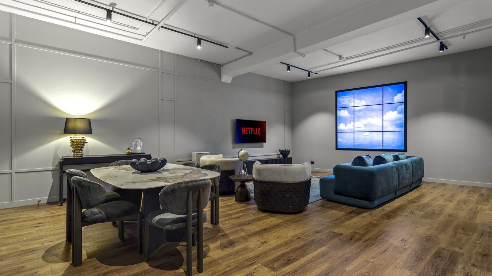 A modern interior with a dining area, a sofa, and a large window.