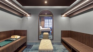 A hotel room with a mirrored wall, a bed, a bench, and a small table with a towel. - Heritage Residence Four Bedrooms Four Bathrooms (Auckland City)