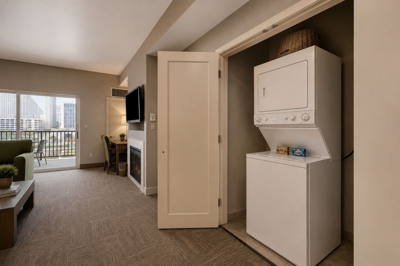 Un espacio habitable compacto con kitchenette, televisor de pantalla plana, comedor y vistas a la ciudad.
