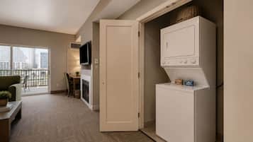 Un espacio habitable compacto con kitchenette, televisor de pantalla plana, comedor y vistas a la ciudad.